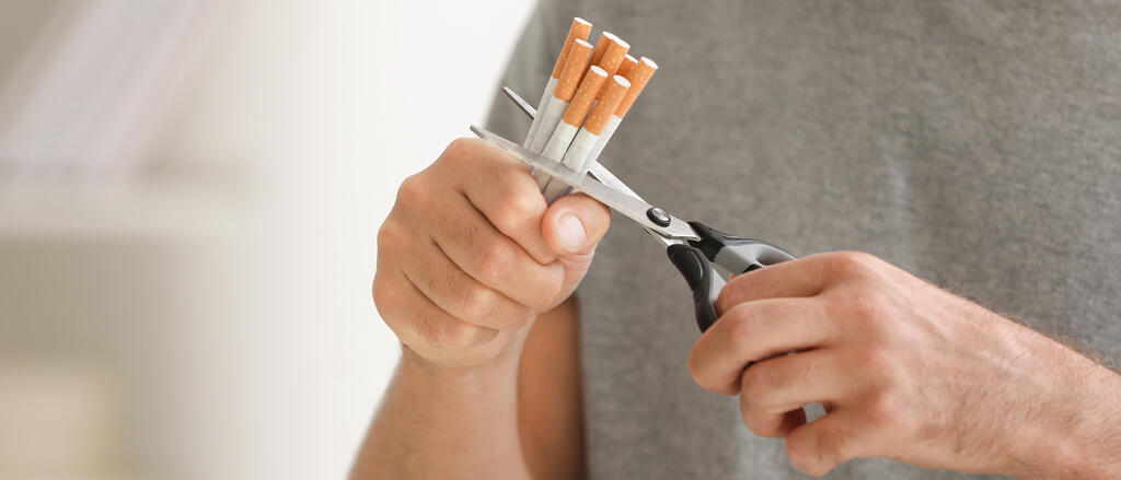 Symbolbild: Ein Bündel Zigaretten wird mit einer Schere durchgeschnitten