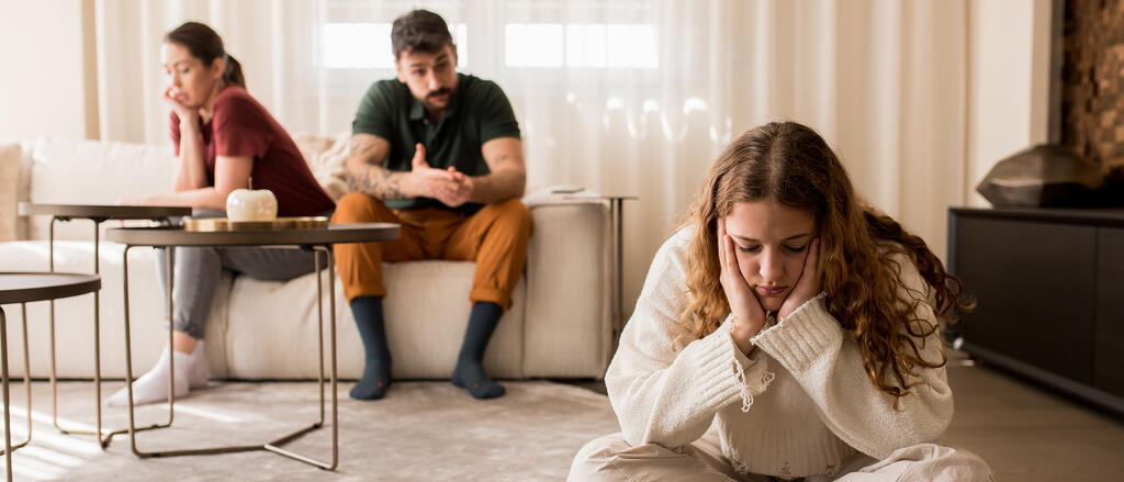 Eine Tochter wendet sich traurig von ihren Eltern ab